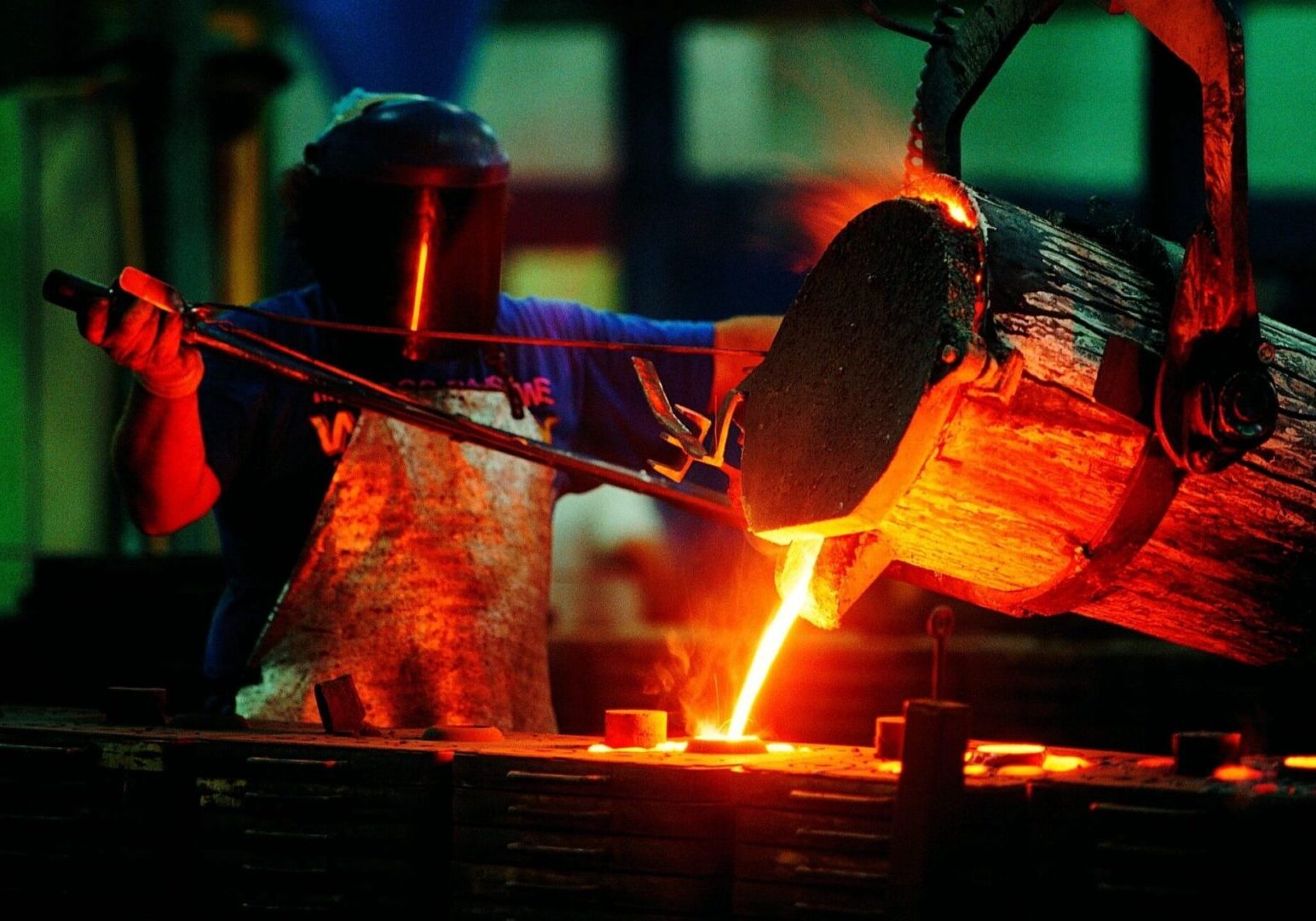 A person working in an iron foundry at night.