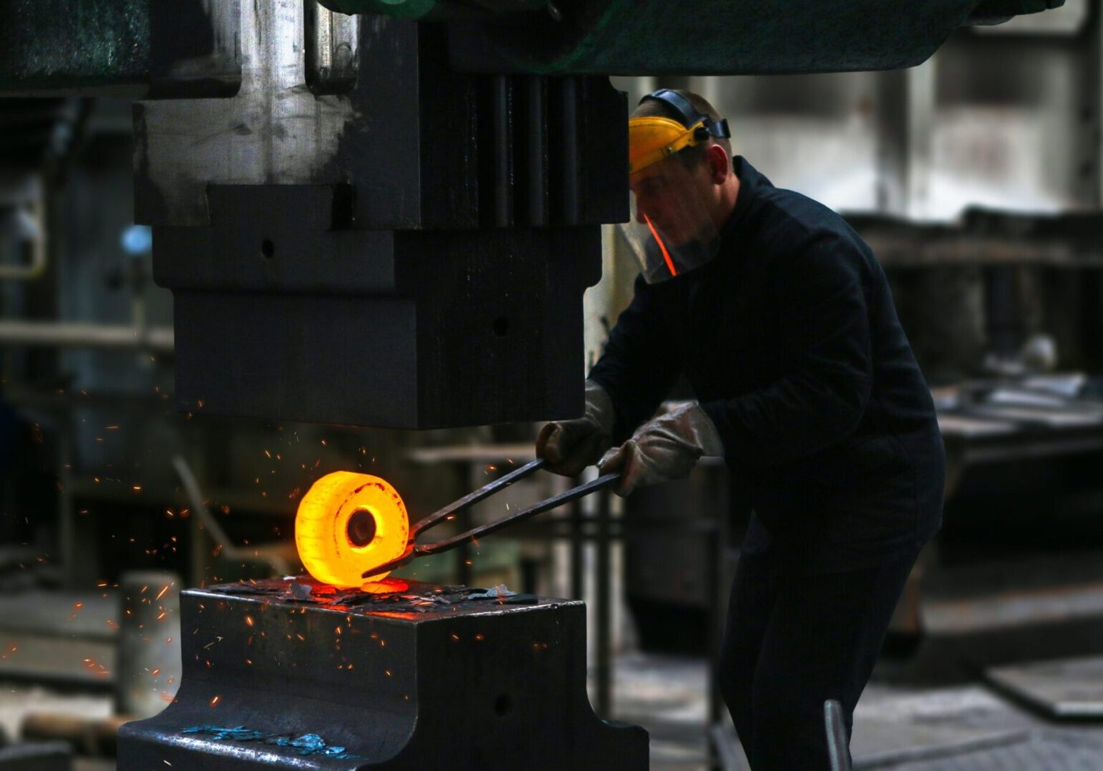 A man in black shirt working with metal object.